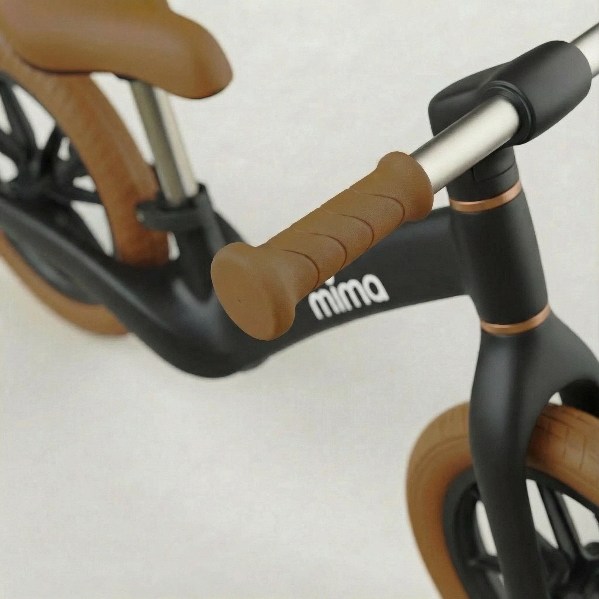 Close-up of a Black bicycle with handlebar grips and 'mima' branding