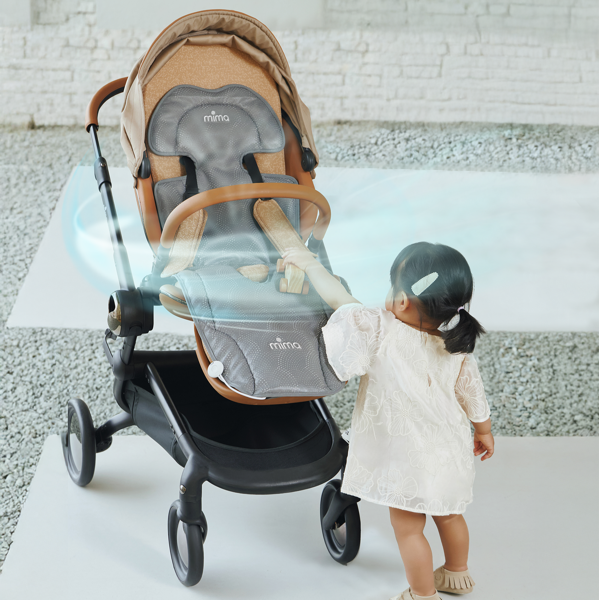 toddler girl standing next to a creo stroller with flo oreo seat pad in grey