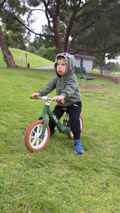 Niño aprendiendo equilibrio en bicicleta sin pedales Mima Zoom Lite en parque sobre hierba